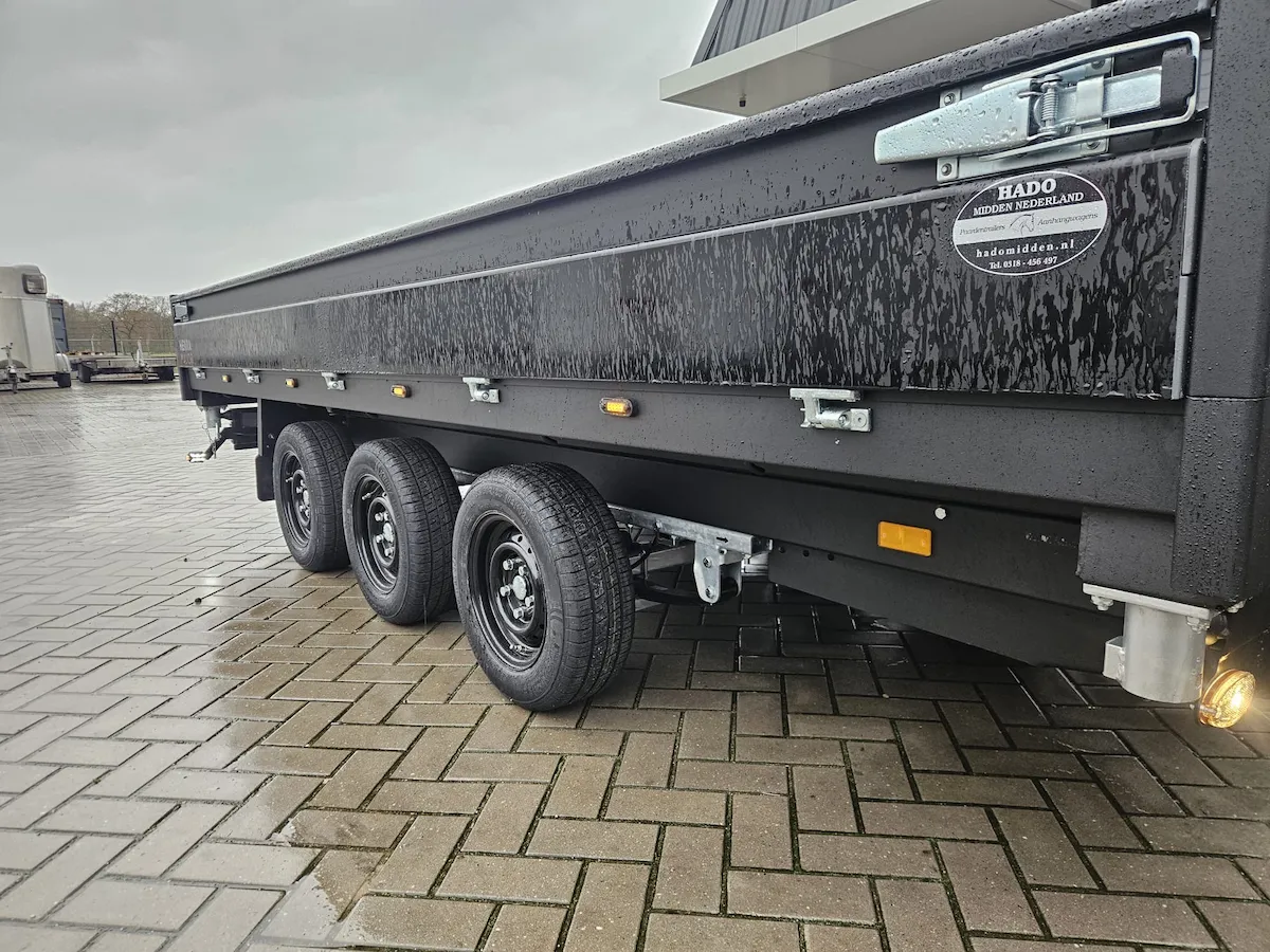 Amber LED warning beacon mounted on the rear of a commercial trailer, lit against a grey sky